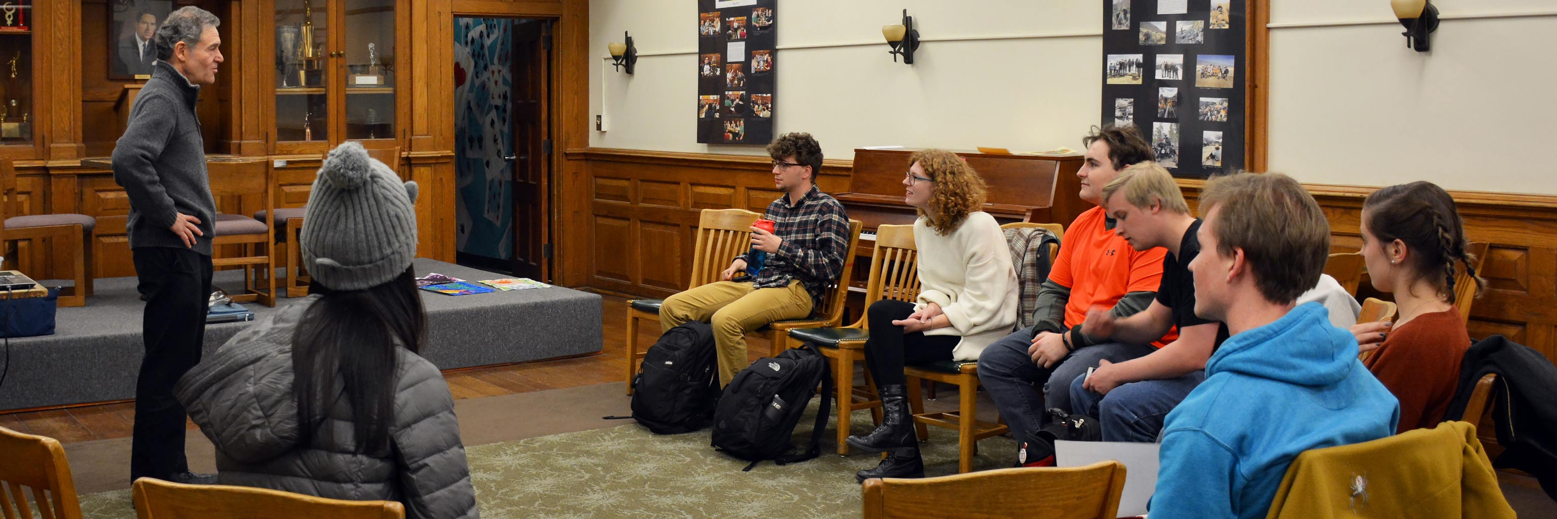 A professor lectures to a small group of engaged students